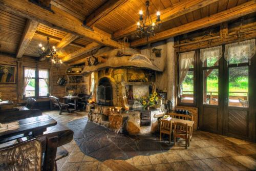 a large room with a stone fireplace in a log cabin at Dworek Sanocki in Sanok