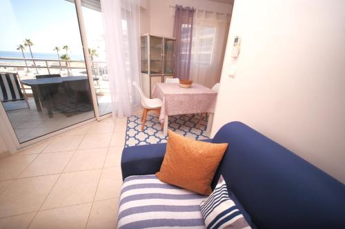 d'un salon avec un canapé bleu et d'un balcon. dans l'établissement Grand F2 Bastia, Port de Toga, Terrasse Vue Mer, à Bastia
