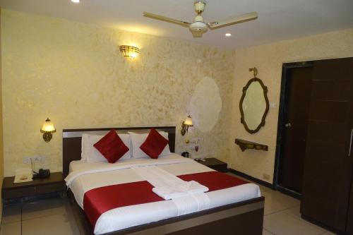 a bedroom with a large bed with red and white pillows at Hotel Sunshine Airport in Mumbai
