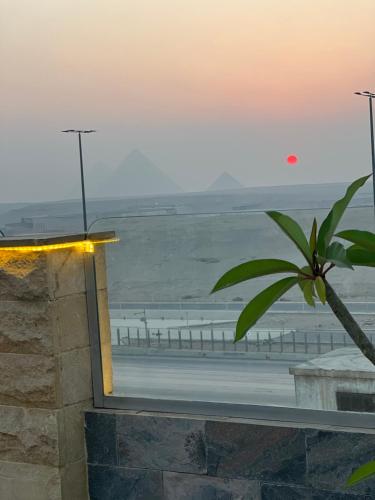 ‘Ezbet `Abd el-ḤamîdにあるPyramids Desert Gate Hotelの建物から夕日のビーチを望めます。