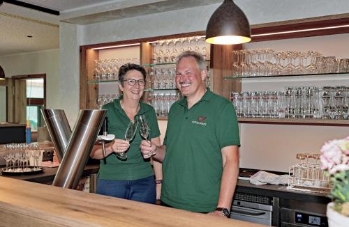a man and a woman standing at a bar at Hotel zur Post 3 Sterne superior in Altenahr