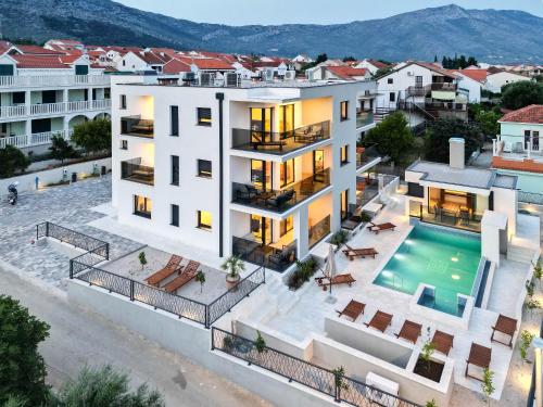 an aerial view of a white apartment building with a swimming pool at Luxury Apartments Villa MTG in Orebić