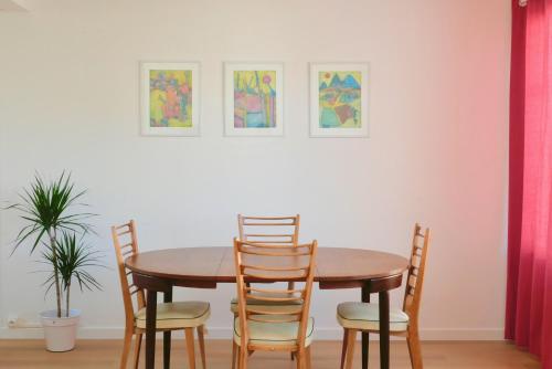 - une table et des chaises dans une pièce ornée de peintures dans l'établissement Bel appartement, 3 chambres et parking, Montpellier centre, à Montpellier