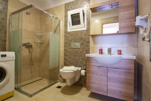a bathroom with a shower toilet and a sink at hotelsunnybeachgr in Perdika