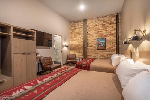 a hotel room with two beds and a brick wall at Crosby Lofts in Crosby