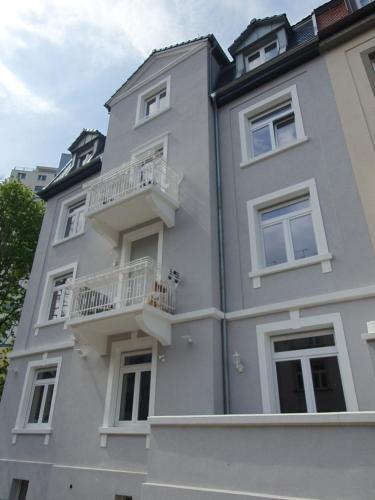 un edificio blanco con balcones en un lateral en EG Weststadt Karlsruhe 4 Zimmer en Karlsruhe