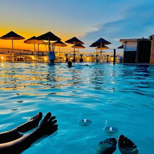 a person laying in the water in a swimming pool at MORF suites in Casale Marittimo