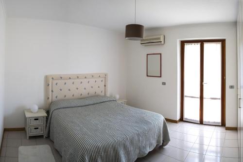 - une chambre blanche avec un lit et une fenêtre dans l'établissement Elegant apartment in residence with pool, à Acireale