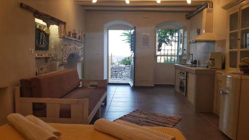 een woonkamer met een bank en een keuken bij ALEMINAS HOUSE in Symi