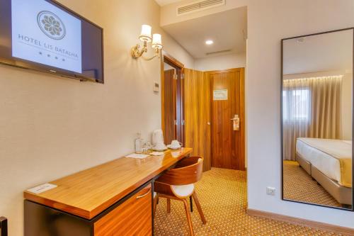 a hotel room with a desk and a bed at Hotel Lis Batalha in Batalha