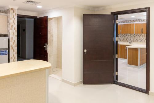 une cuisine avec une porte coulissante et un comptoir. dans l'établissement Mooj Apartments Hotel- فندق موج للشقق الفندقية, à Dammam