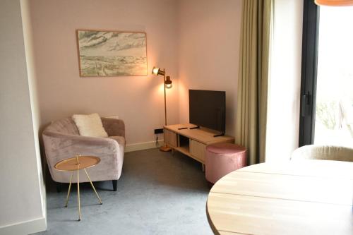 a living room with a couch and a television at Kerkhotel Bij De Pastorie in Reitsum