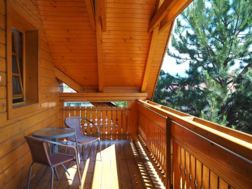 a porch with two chairs and a table on it at Privat Alenka in Liptovský Mikuláš