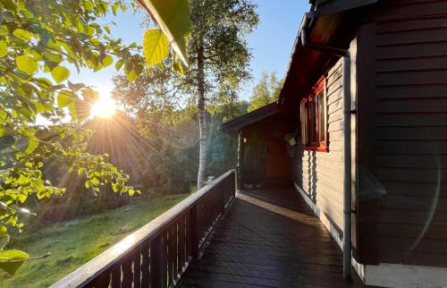einen Holzsteg, der zu einer Hütte mit Sonnenuntergang führt in der Unterkunft Voss Waterfalls - Norway Mountain Cabin & Traveller Award Winner! in Vossevangen