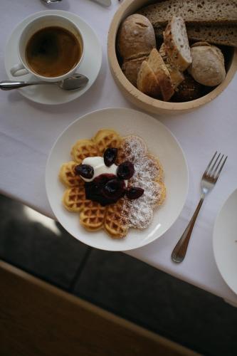 a plate of waffles on a table with a cup of coffee at Naturhotel Leitlhof in San Candido