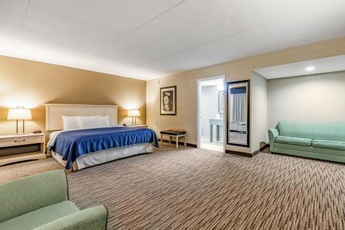 トゥーペロにあるSureStay Hotel by Best Western Tupelo Northのベッドとソファ付きの広いホテルルームです。