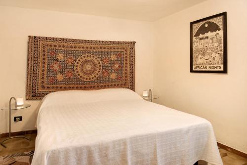 a bedroom with a bed with a rug on the wall at Casafiò Grotta in Cassinasco
