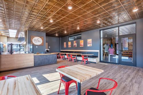 a restaurant with tables and red chairs in a room at Crosby Lofts in Crosby