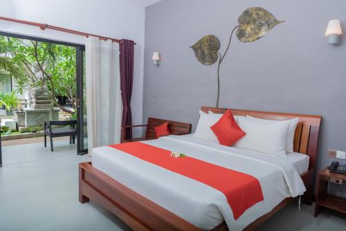 sypialnia z łóżkiem i dużym oknem w obiekcie New Riverside Hotel w Siem Reap