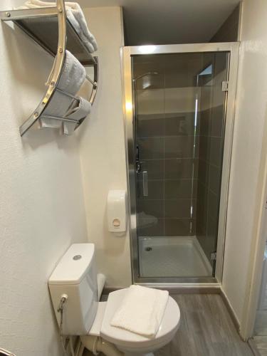 uma casa de banho com um WC e uma cabina de duche em vidro. em Contact Hotel LE SUD Montpellier Aéroport Parc Expo Arena em Mauguio