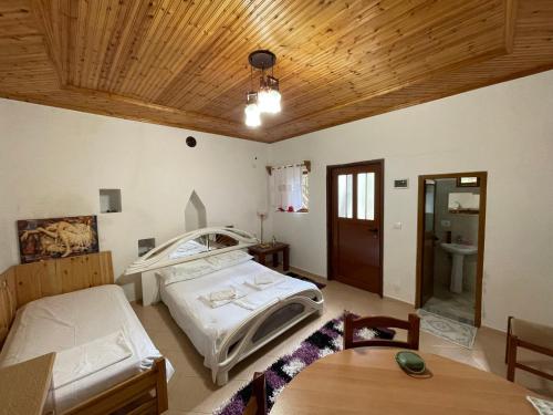 a room with two beds and a table in it at Guest House Bakuli in Gjirokastër