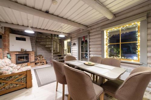 a dining room with a table and chairs and a fireplace at Rasos Vila in Palanga