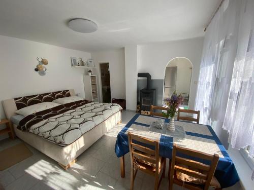 1 dormitorio con 1 cama, mesa y sillas en Apartmán BENÍŠKOVEC, Suchdol nad Lužnicí, en Suchdol nad Lužnicí