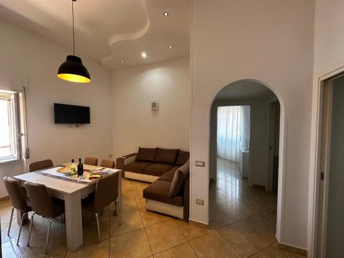 una sala de estar con una mesa y un sofá en Casa Bellella, en Torre Annunziata