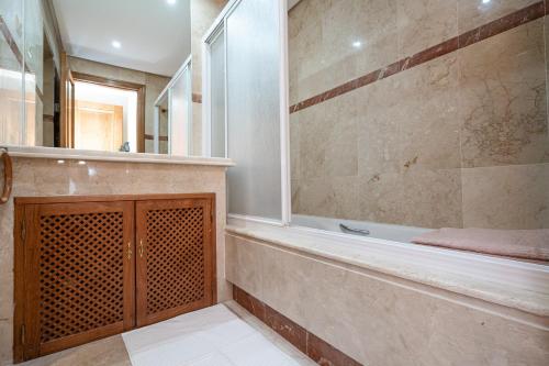 ein großes Bad mit einer Dusche und einer Badewanne in der Unterkunft Costalita Beach Apartment in Estepona