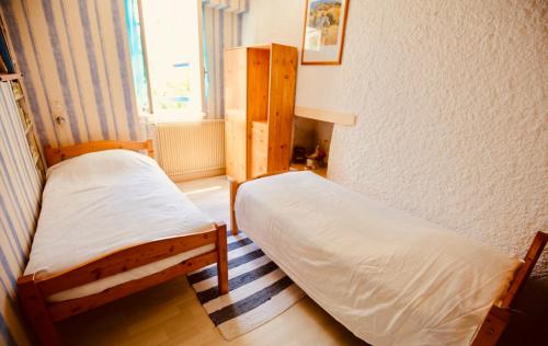 sypialnia z 2 łóżkami i oknem w obiekcie Les Volets Bleus w mieście Sauvignac