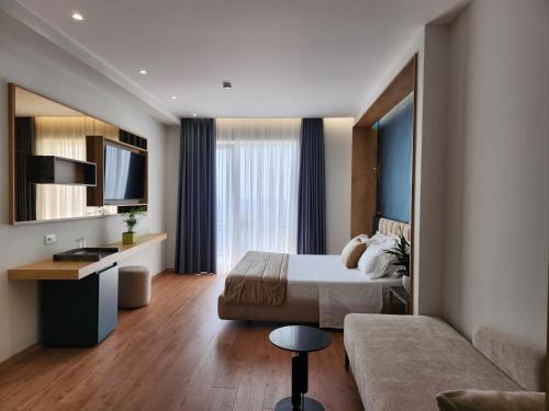 a hotel room with a bed and a couch at Hotel Gold in Vlor&euml;