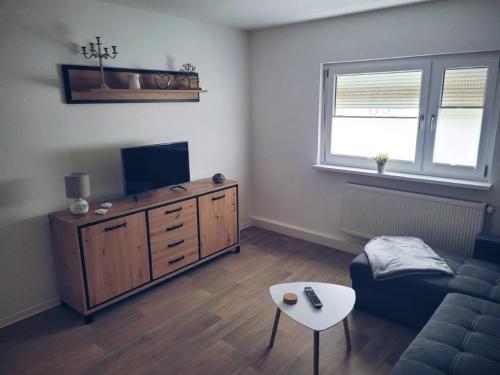 a living room with a couch and a flat screen tv at Gästehaus Ehrhardt in Merseburg