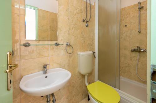een badkamer met een wastafel, een toilet en een douche bij Apartmani Frka in Sali