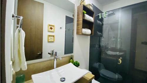 y baño con lavabo y ducha. en Hermoso apartamento, en Cartagena de Indias