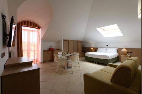 um quarto de hotel com uma cama e uma sala de estar em Hotel & Apartments Sasso em Diano Marina