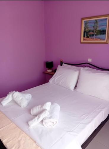 a bedroom with a white bed with towels on it at By the sea dome in Maronia