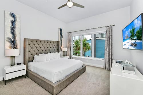 a white bedroom with a bed and a window at Lovely Condo near Disney w Hotel Amenities - 7770-26-210 in Kissimmee