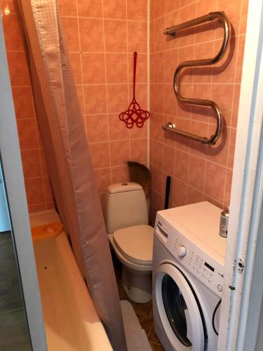 a bathroom with a toilet and a washing machine at Maleva apartaments in Kohtla-Järve