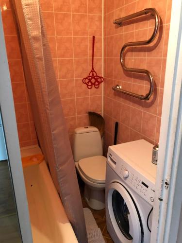 y baño con aseo y lavadora. en Maleva apartaments, en Kohtla-Järve