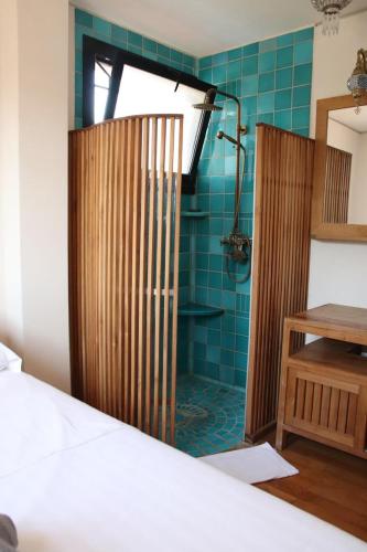 a bathroom with a shower with blue tile at T2 dans une résidence au coeur du Brusc in Six-Fours-les-Plages