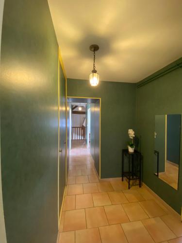 a hallway with green walls and a light fixture at Domaine Les Hauts Prés in Villaines-les-Prévôtes