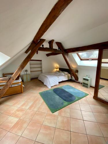 a bedroom with a bed and a rug on the floor at Domaine Les Hauts Prés in Villaines-les-Prévôtes