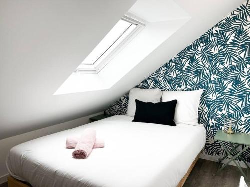 um quarto com uma cama branca e uma clarabóia em T4 Pamplemousse Cosy proche plages et commerces em Saint-Nazaire