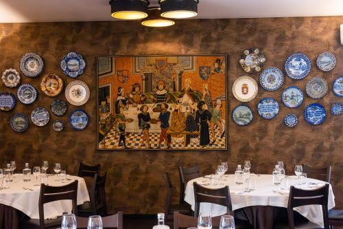 a wall with plates and tables in a restaurant at Hotel Lis Batalha in Batalha