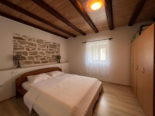 1 dormitorio con cama y pared de piedra en Apartment Anamarija, en Poreč