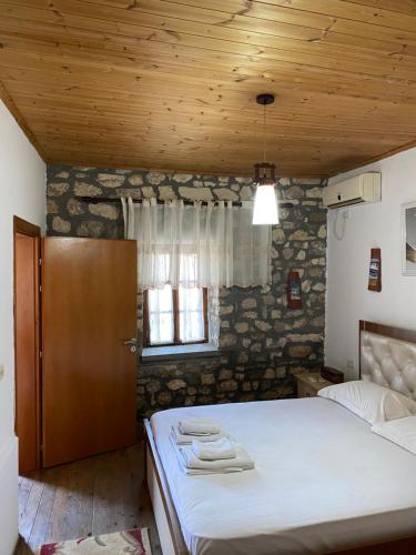 1 dormitorio con cama y techo de madera en Aria Baci Guest House, en Berat