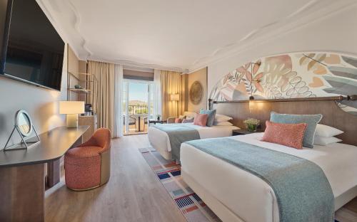 a hotel room with two beds and a desk at Grand Hyatt La Manga Club Golf & Spa in La Manga del Mar Menor