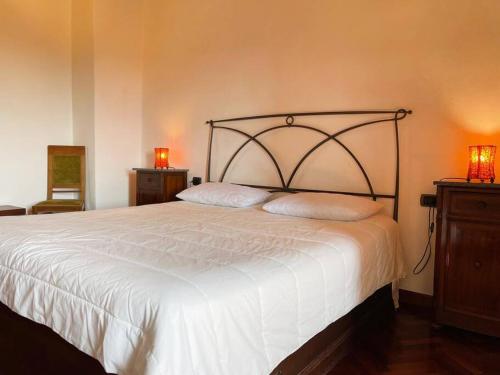 1 dormitorio con 1 cama blanca grande y 2 almohadas en Appartamento toscano Pelago - Firenze en Pelago