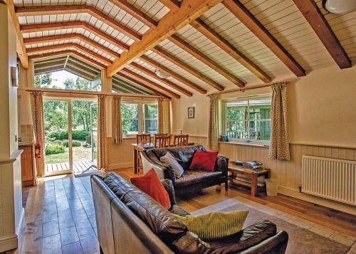 sala de estar con muebles de cuero y ventana grande en Great Wood Lodges, en Flaxton