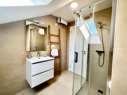 een badkamer met een wastafel en een douche bij Balnea Troncoso in Mondariz-Balneario